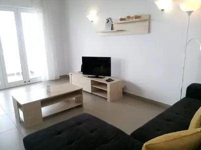 a living room with a couch and a tv at Mamamia AC&Vista Magnifica in Quarteira
