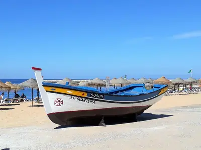 a boat sitting on the sand on a beach at Mamamia AC&Vista Magnifica in Quarteira