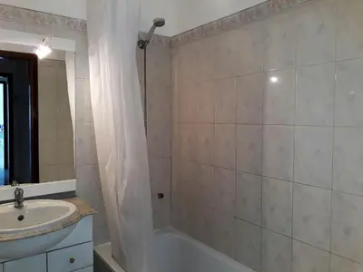 a bathroom with a shower and a sink and a tub at SATÉLITE AC&Garagem in Quarteira