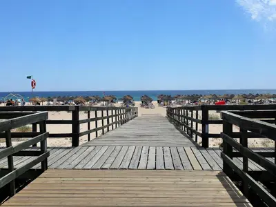 a wooden boardwalk leading to the beach at V2 Aldeia Do Golf- Piscina, Familiar, Aconchegante in Vilamoura