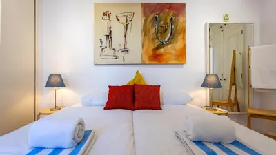a bedroom with a white bed with red pillows at 3 Bed Holiday Home Lakeside Village Quinta Do Lago in Faro