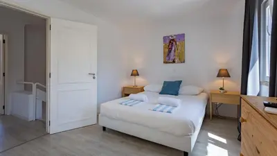 a bedroom with a white bed with blue pillows at 3 Bed Holiday Home Lakeside Village Quinta Do Lago in Faro