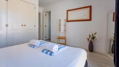 a bedroom with a white bed with towels on it at 3 Bed Holiday Home Lakeside Village Quinta Do Lago in Faro