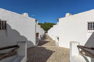 an alley with white buildings and a blue sky at FLH Albufeira Açoteias Apartment in Albufeira