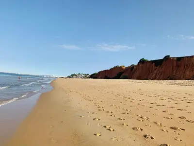a beach with footprints in the sand and the ocean at Beach Villa Vale do Lobo in Vale do Lobo