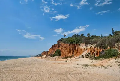 a beach with a lot of umbrellas and people on it at Beach Villa Vale do Lobo in Vale do Lobo