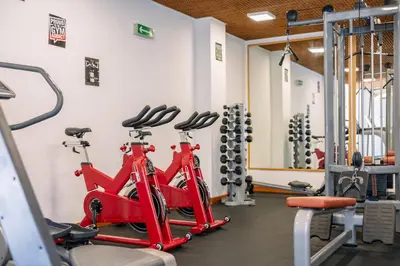 a gym with two red bikes and weights at Muthu Oura Praia Hotel in Albufeira