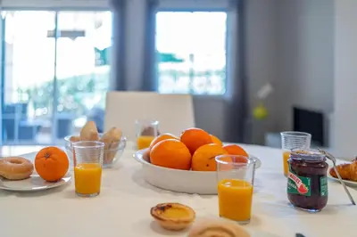 a table with a bowl of oranges and glasses of orange juice at Villa Balaia by HelloVacations in Albufeira