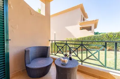 a balcony with a blue chair and a table at Villa Balaia by HelloVacations in Albufeira