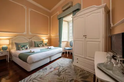 a bedroom with a king sized bed and a dresser at Casa Beny 1897 Guesthouse in Loulé