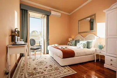 a bedroom with a bed and a mirror and a window at Casa Beny 1897 Guesthouse in Loulé