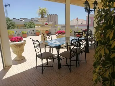 a glass table and chairs on a patio at Casa Beny 1897 Guesthouse in Loulé