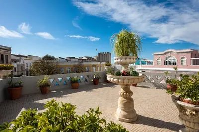 a terrace with potted plants on a balcony at Casa Beny 1897 Guesthouse in Loulé