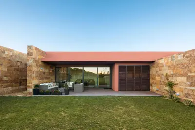 a modern house with a brick wall at L Orangerie CA by Intiholidays in Vilamoura