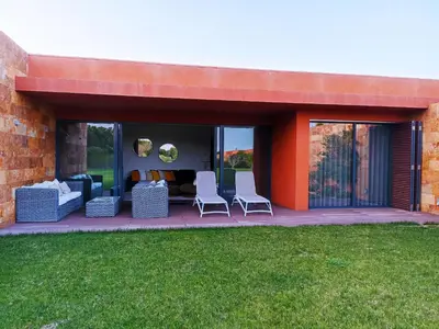 acovered patio with two chairs and a couch at L Orangerie CA by Intiholidays in Vilamoura