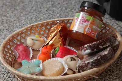 a basket filled with cookies and a jar of jam at Casa das Andorinhas in Faro