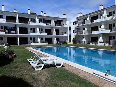 a swimming pool with two lounge chairs in front of a building at Mouramar- Garagem, Piscina & Wifi in Vilamoura