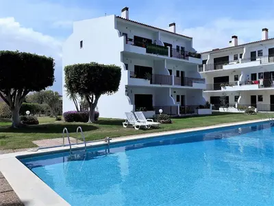 a hotel with a swimming pool in front of a building at Mouramar- Garagem, Piscina & Wifi in Vilamoura