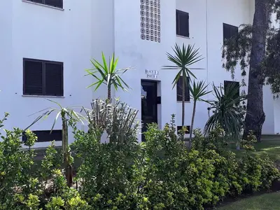 a white building with plants in front of it at Mouramar- Garagem, Piscina & Wifi in Vilamoura