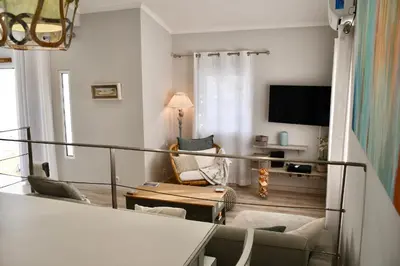 a living room with a couch and a tv at Aquamarine - Gemstone Getaway in Vale do Lobo