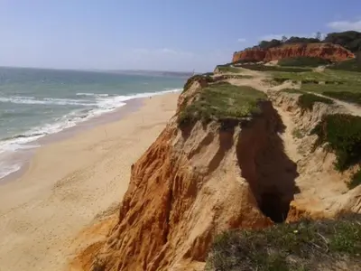 a sandy beach next to the ocean with a cliff at Apartamento Praia da Falésia in Albufeira