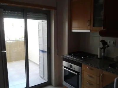 a kitchen with a glass door leading to a patio at Apartamento Praia da Falésia in Albufeira