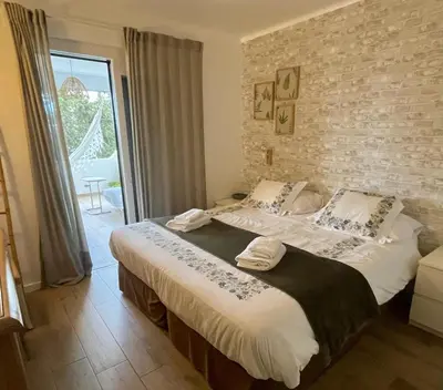 a bedroom with two beds and a brick wall at ExcelStay - Balaia in Albufeira