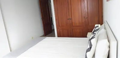 a bedroom with a bed and a wooden door at Avenida Mar- Vista Mar, Wifi, 150mt Praia in Quarteira