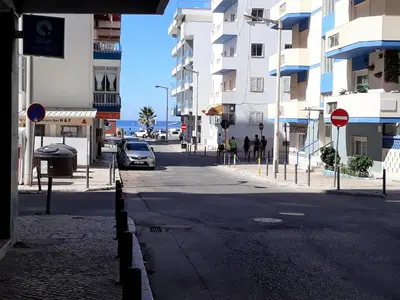a city street with a car parked on the road at T2 Mira Praia 4- Familiar, 80mt Praia, Wifi in Quarteira