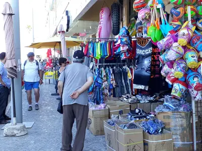 a man standing in front of a store in a market at T2 Mira Praia 4- Familiar, 80mt Praia, Wifi in Quarteira