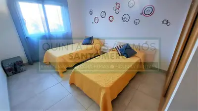 a bedroom with two beds and a clock on the wall at Apartamento Vitismar CA in Guia