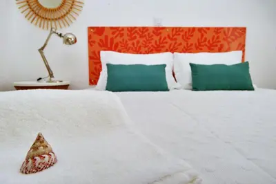 a bedroom with a white bed with a pineapple on it at Son of a Beach Hostel in Albufeira
