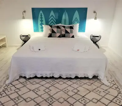 a bedroom with a large white bed with two pillows at Son of a Beach Hostel in Albufeira