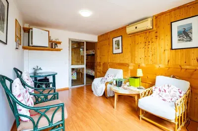 a living room with wooden walls and a table and chairs at Rua Fancisco Barreto in Faro