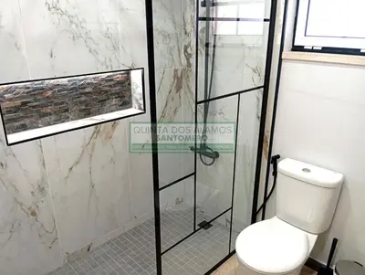 a bathroom with a toilet and a glass shower stall at Moradia Townhouse S Sebastião F in Guia