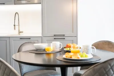 a table with two cups of orange juice and fruit on it at Estúdios Marina in Vilamoura