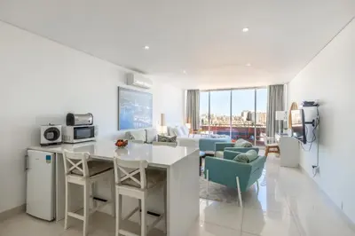 a kitchen and living room with a table and chairs at Estúdios Marina in Vilamoura