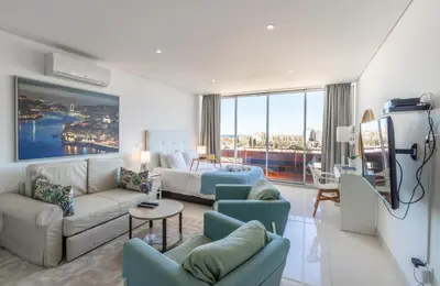 a living room with a bed and a couch and chairs at Estúdios Marina in Vilamoura