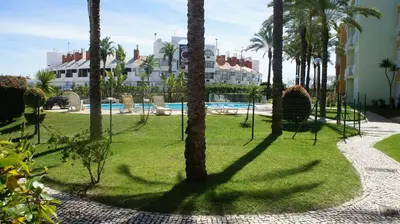 a resort with palm trees and a swimming pool at Pool & Garden Oura Albufeira Flat in Albufeira