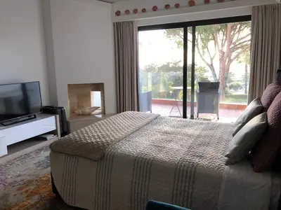 a bedroom with a bed and a large window at Victory Village Club in Quinta do Lago