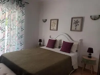 a bedroom with a large bed with purple pillows at Quinta Das Palmeiras in Quarteira