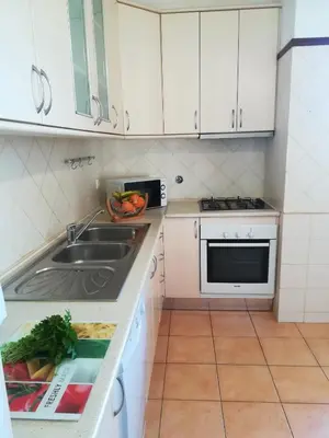 a small kitchen with a sink and a microwave at Quinta Das Palmeiras in Quarteira