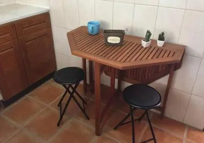 a small wooden table with two stools in a kitchen at Fisherman´s beach apartment in Albufeira