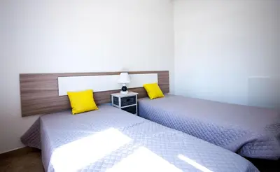 two beds in a room with yellow pillows at Old Town Sant'ana T2 in Albufeira