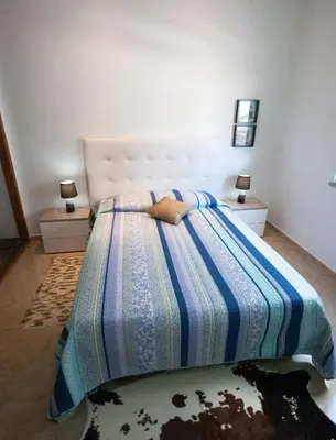 a bedroom with a bed with a blue and white comforter at Old Town Sant'ana T2 in Albufeira