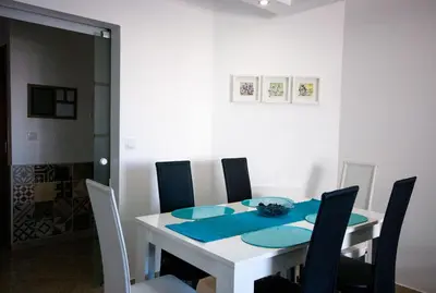 a white dining room table with chairs and a blue napkin at Old Town Sant'ana T2 in Albufeira