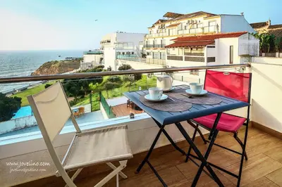 a table and chairs on a balcony with a view of the ocean at Estrela do Mar in Albufeira