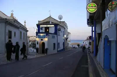 a group of people walking down a street next to a building at Estrela do Mar in Albufeira