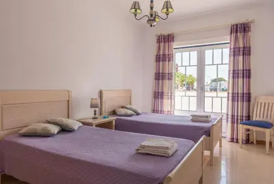two beds in a room with a window at Apartamento Praia da Oura in Albufeira