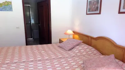a bedroom with a bed and a lamp on a table at Casa Esperança in Albufeira